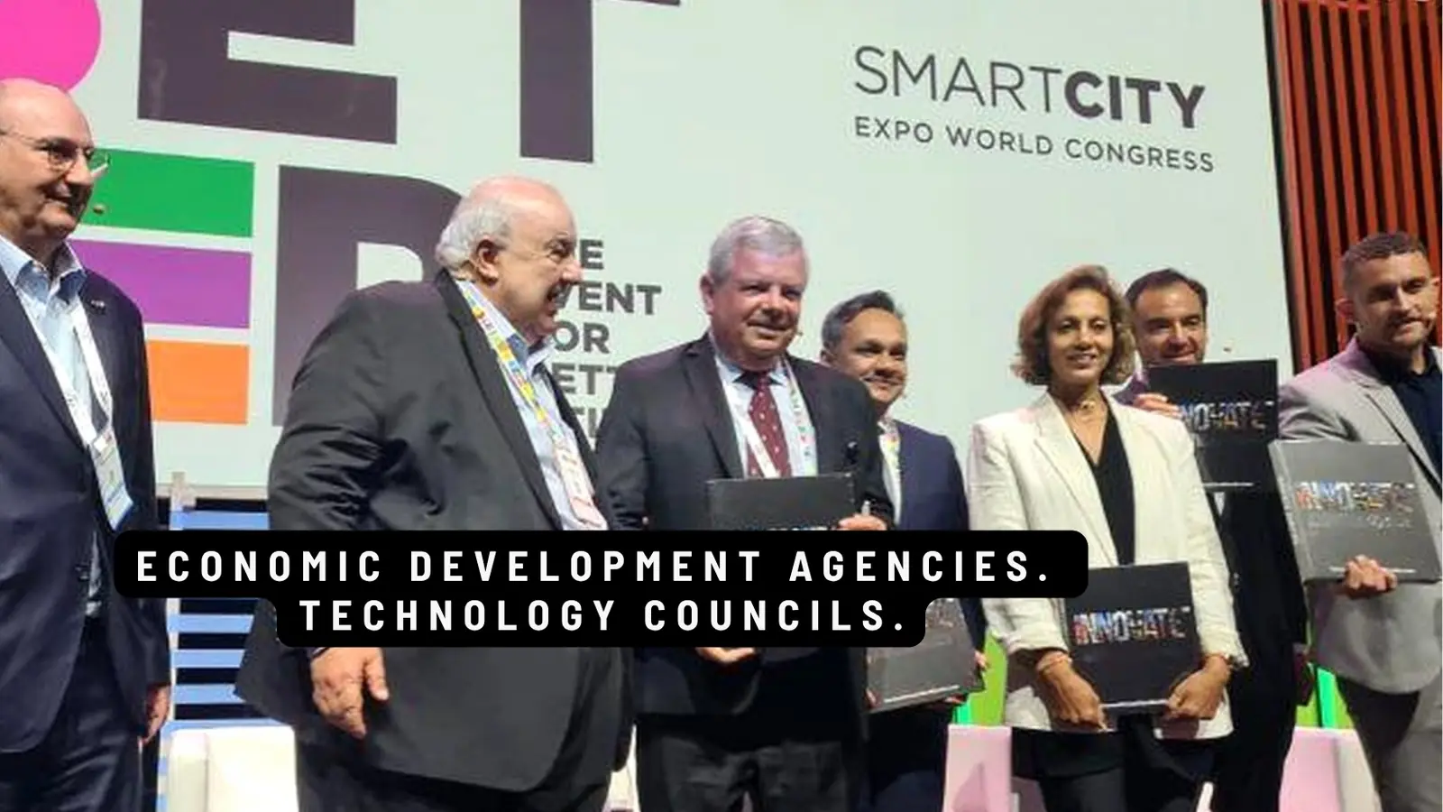 Delegates with INNOVATE books on stage at Smart City Expo World Congress. Caption: Economic development agencies. Technology councils.